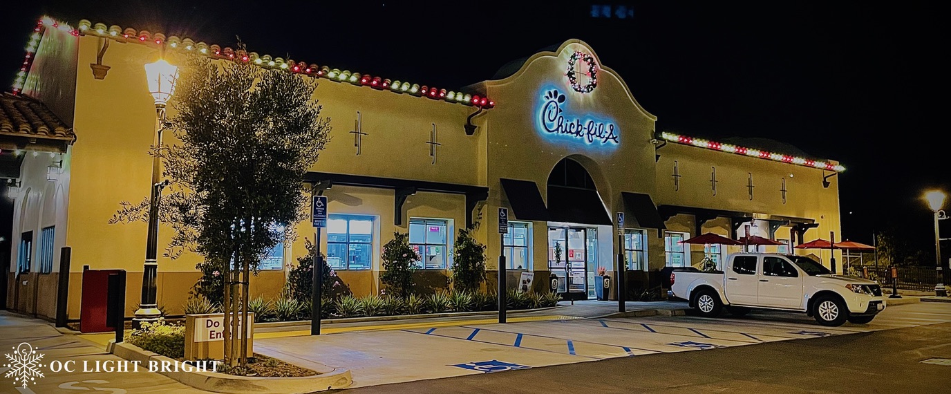 Chick-fil-A entrance and exterior with holiday roofline lighting and a wreath above its sign